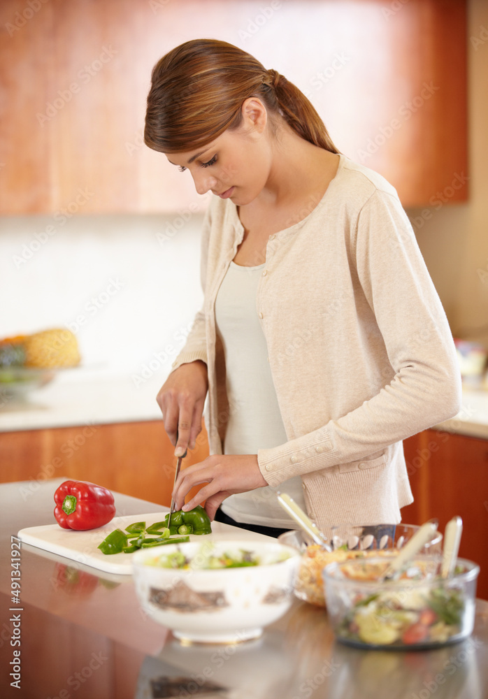 准备一顿饭。一个漂亮的年轻女人在厨房做饭。