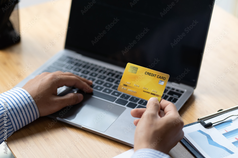 Hands holding credit card and using laptop. Online shopping concept.