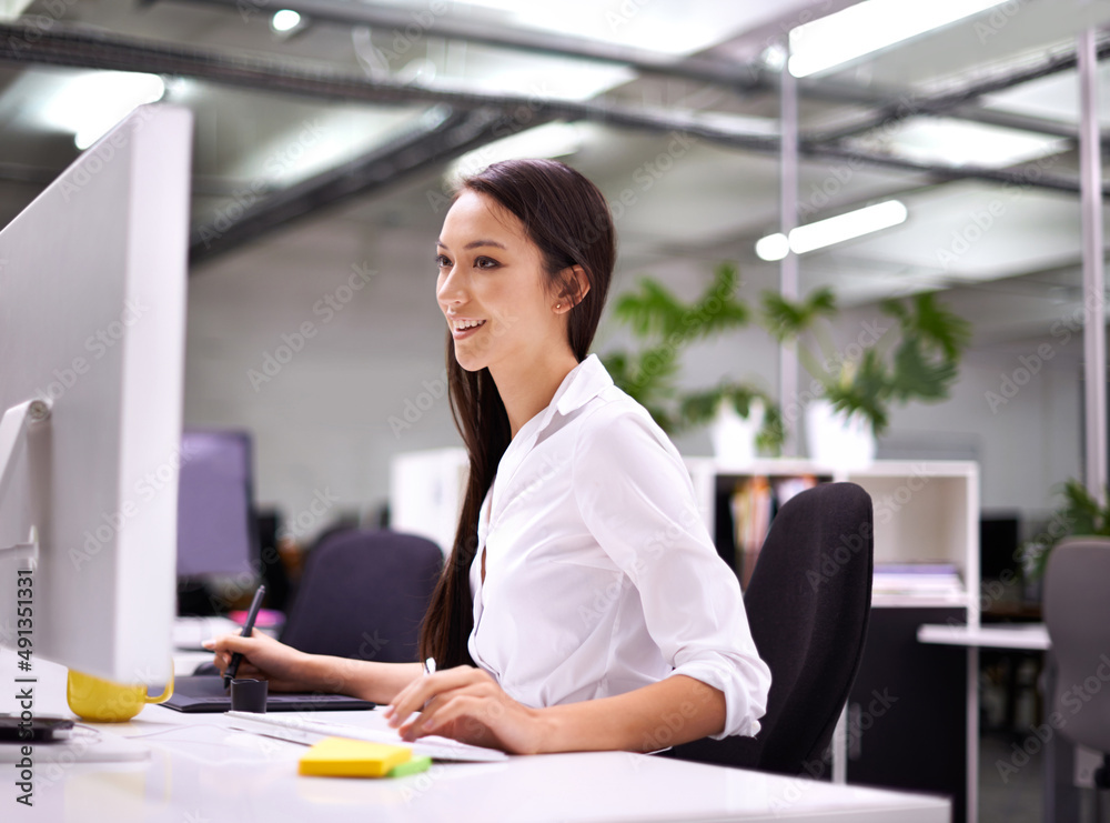 Enjoying every minute of work. Cropped shot of an attractive young woman working at her desk.