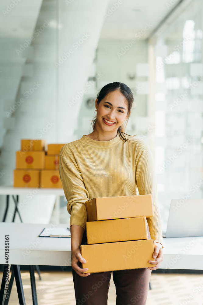 年轻的商业女性在她的商店里进行在线电子商务购物。年轻的女卖家准备parc