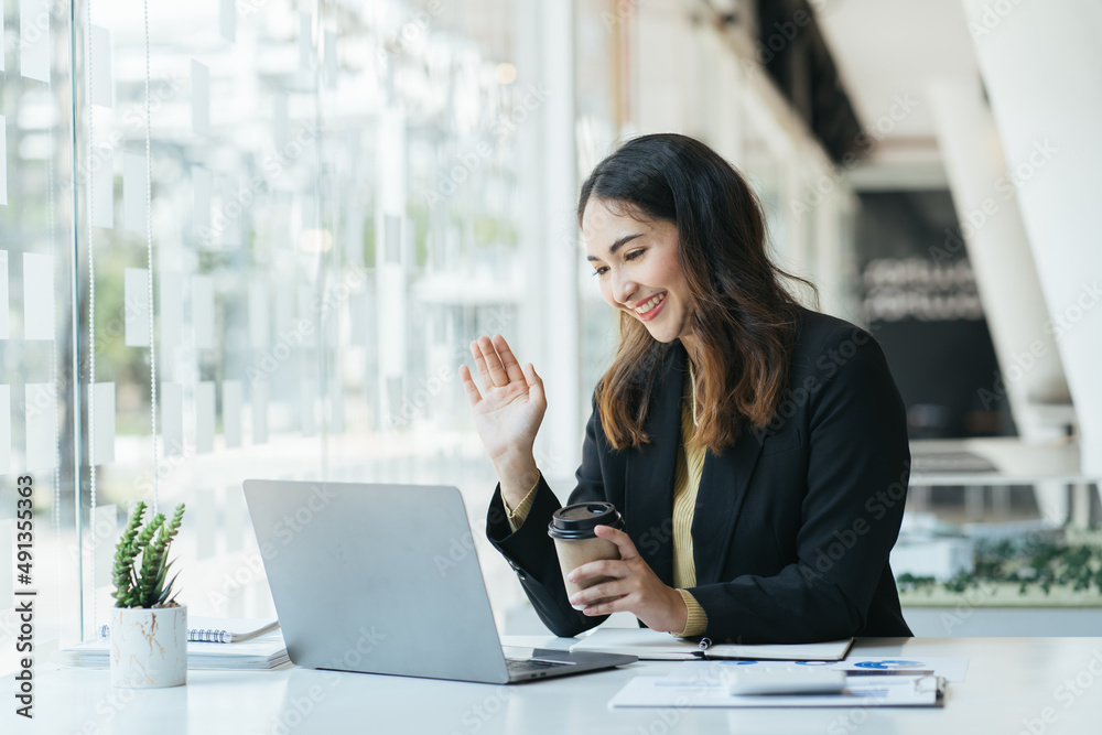 Happy young indian business woman entrepreneur using computer looking at screen working in internet 