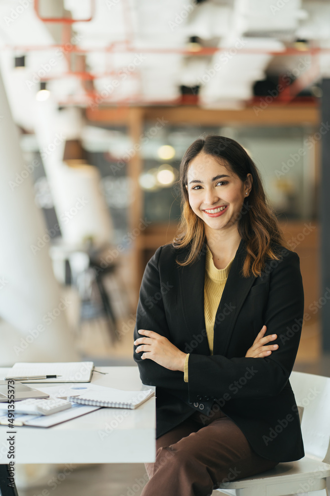 Image of a charming young Asian businesswoman standing at the office. Looking camera.