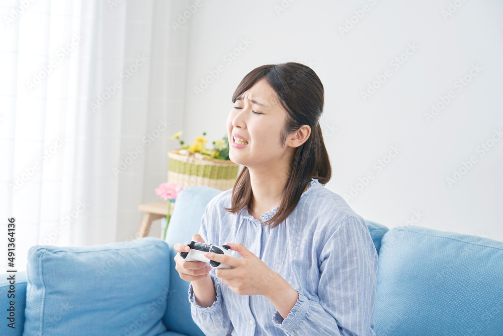 女性　テレビゲーム　落ち込む　リビング