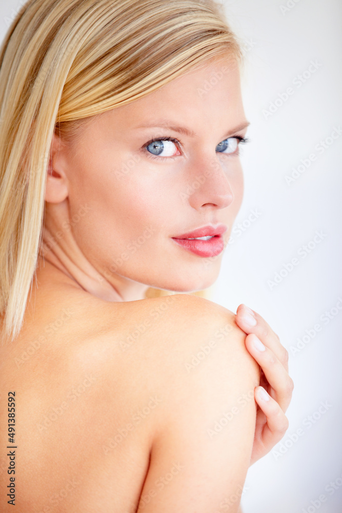 My skin has never felt more beautiful. Beautiful young woman touching her skin against a white backg