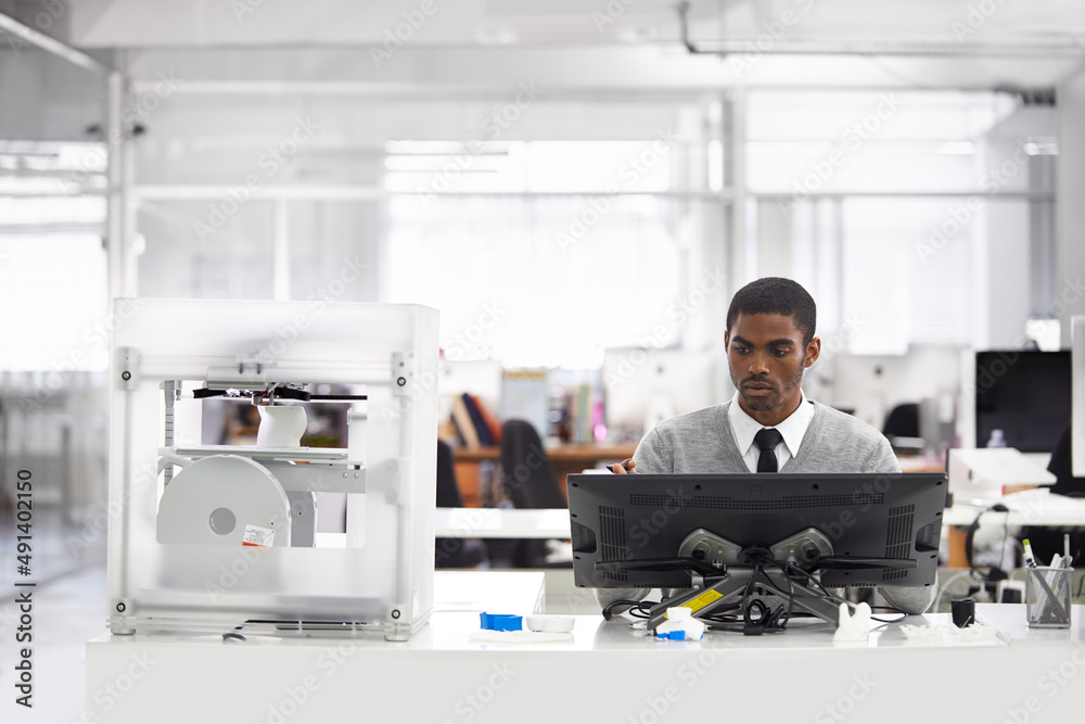 3D printing is the way forward. Cropped shot of a young man printing his designs on a 3D printer.