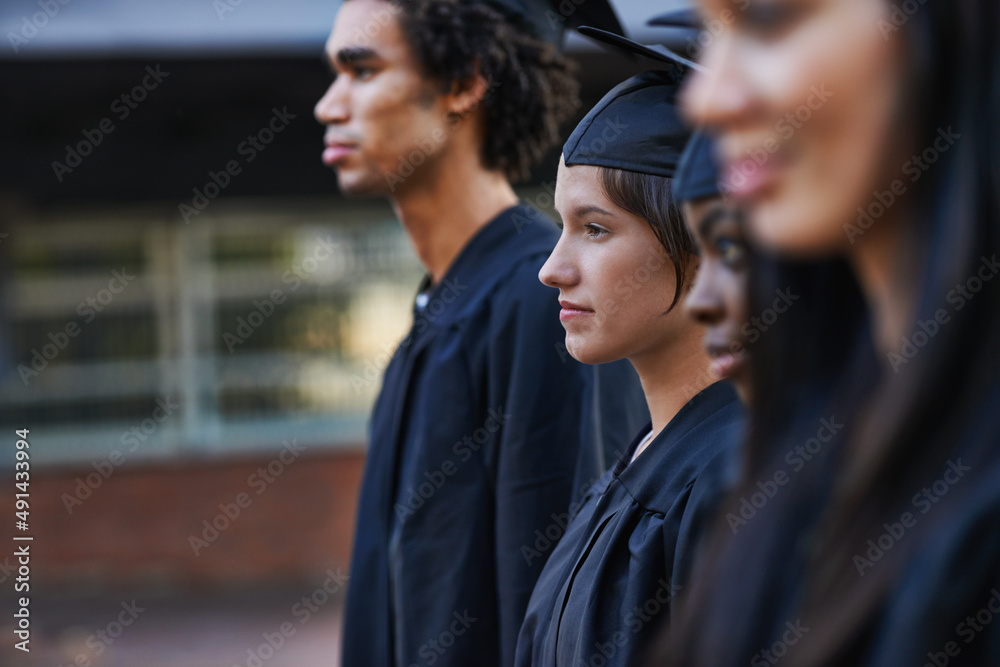 面向毕业生的未来。一群庄严的大学毕业生在毕业典礼上排队。