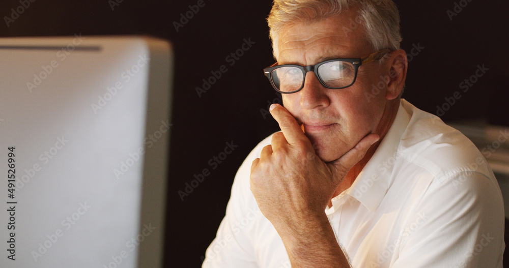 Im the man for the job. Cropped portrait of a mature businessman sitting at his desk in the office.