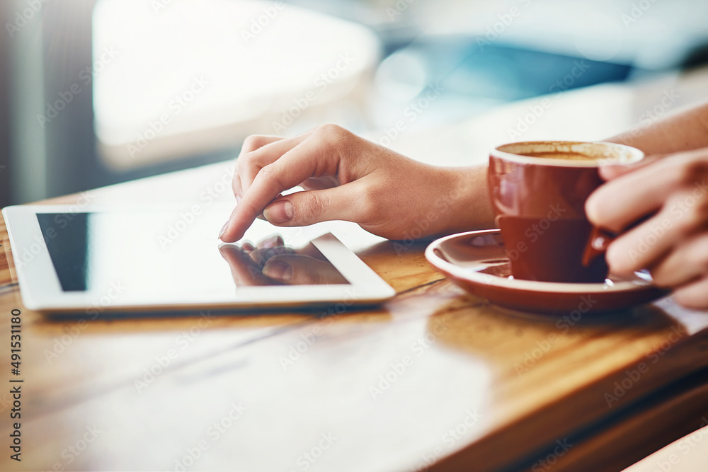 Nothing better than great coffee and wifi. Cropped shot of a woman using a digital tablet in a coffe