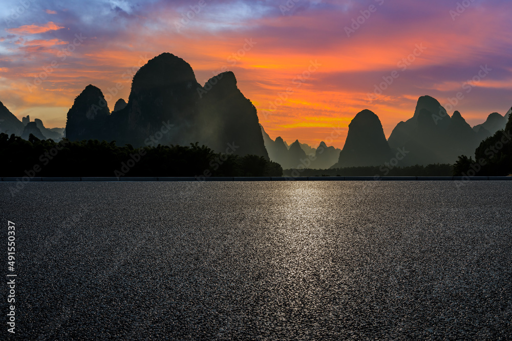 Asphalt road and mountain natural scenery at sunset. Road and mountain background.