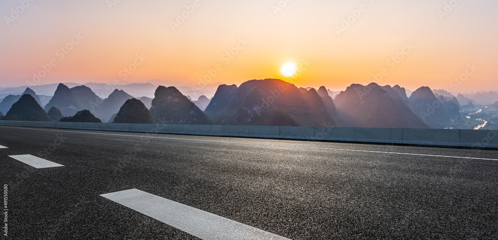 日落时的沥青公路和山脉自然风光。道路和山脉背景。