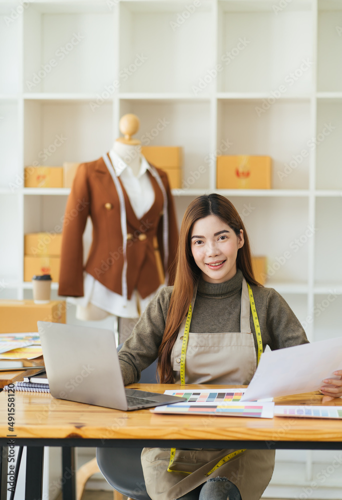 Attractive female fashion designer is working in her workshop. Stylish woman in process of creating 