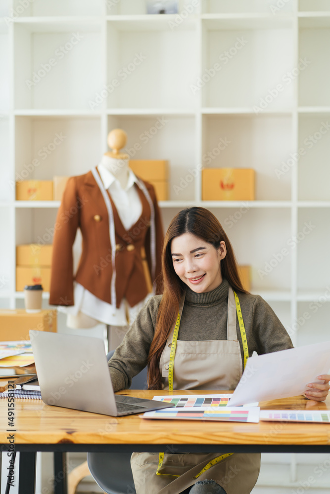 Attractive female fashion designer is working in her workshop. Stylish woman in process of creating 