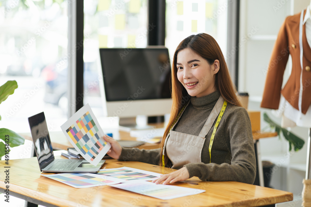 Attractive female fashion designer is working in her workshop. Stylish woman in process of creating 