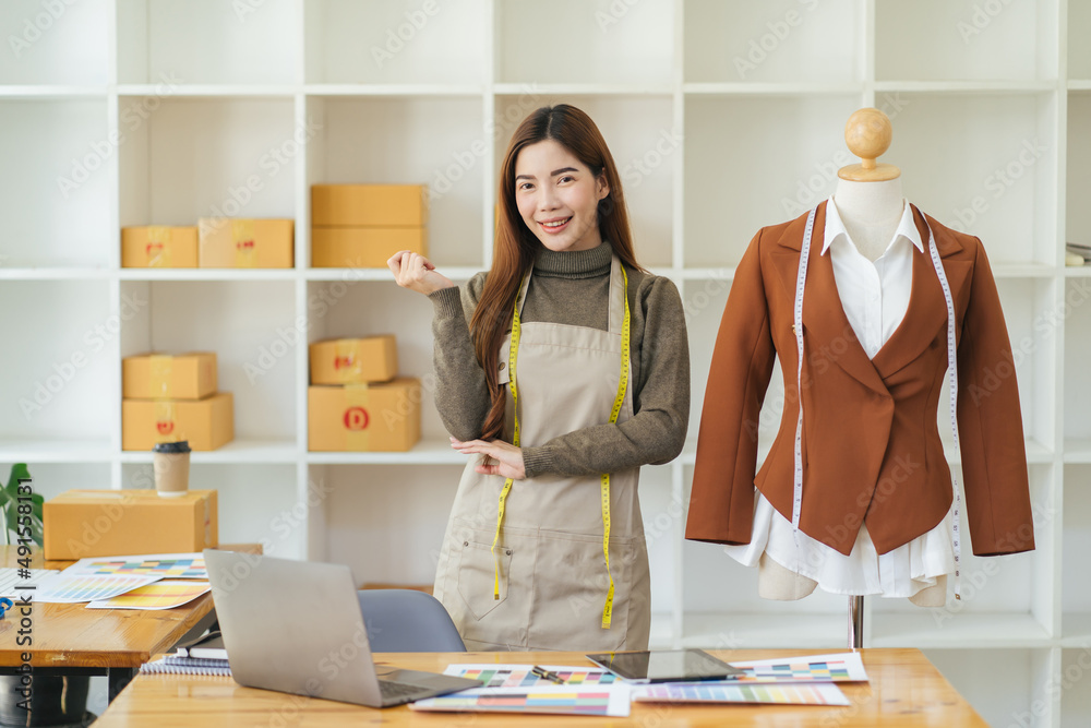 Female fashion designer works on new womenswear collection for clients in cozy workshop studio, dres