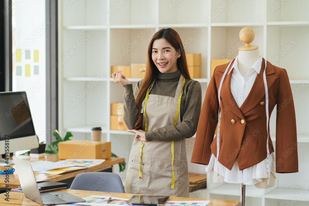 Female fashion designer works on new womenswear collection for clients in cozy workshop studio, dres