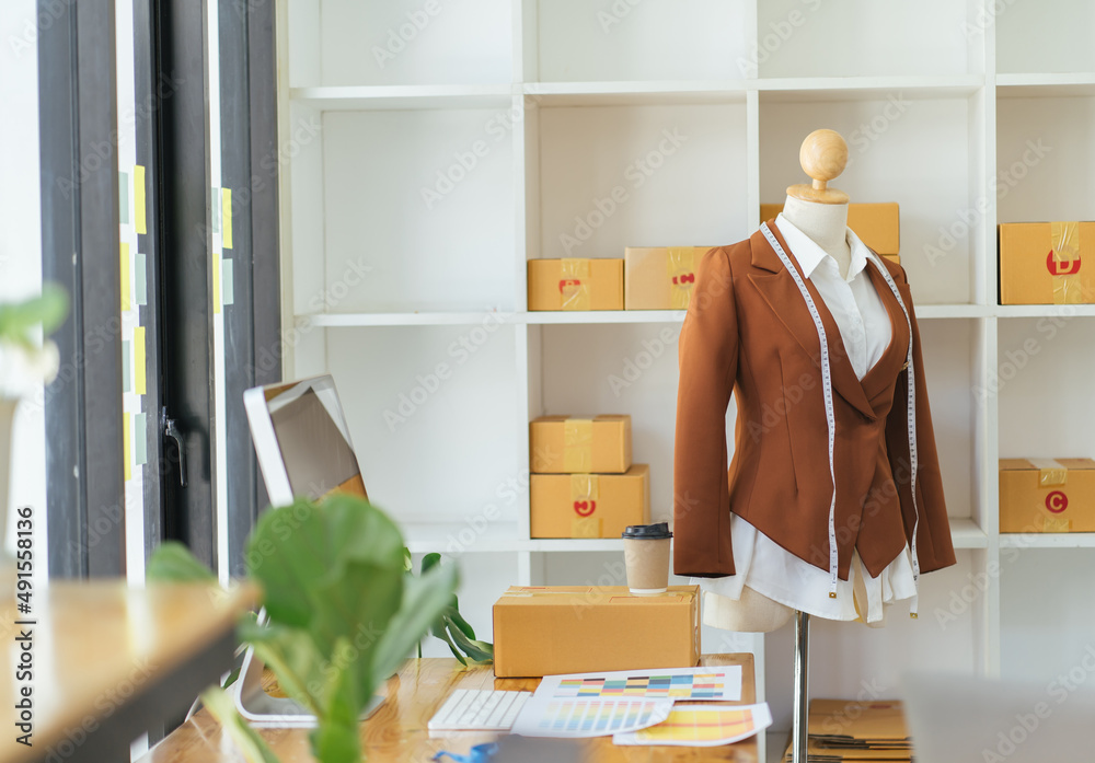 White dummy with measuring tape in tailors studio.