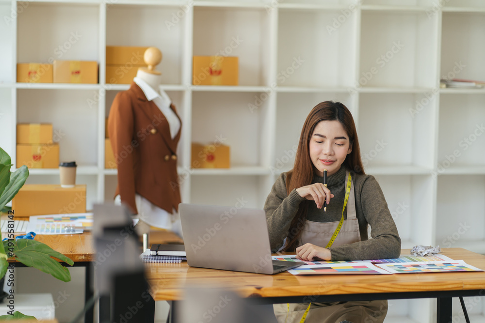 Asian woman designer are thinking and drawing something on paper for customers order items at the de