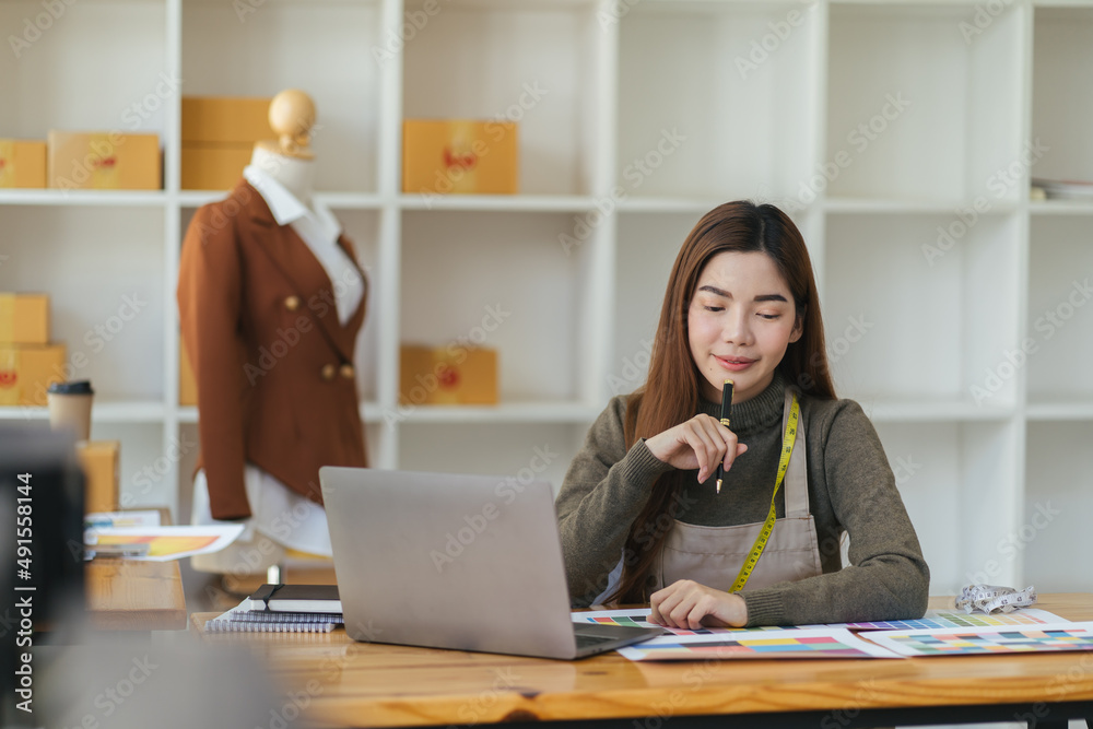 Asian woman designer are thinking and drawing something on paper for customers order items at the de