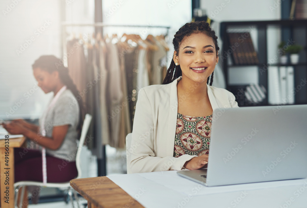 Getting inspiration from her competitors online. Shot of a fashion designer working on her laptop wi