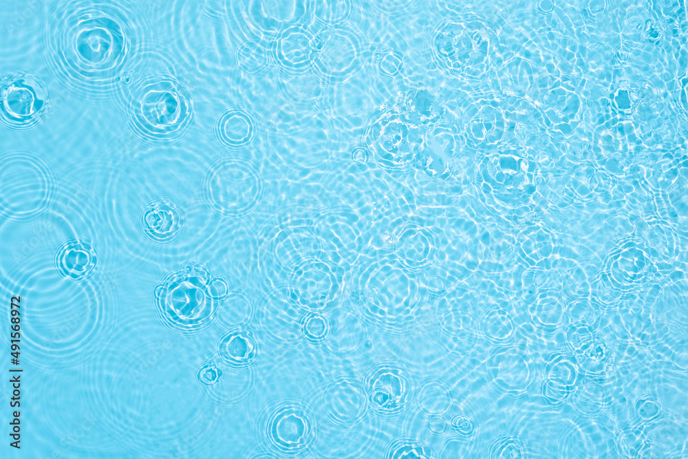 Transparent blue colored clear water surface texture with ripples, splashes and bubbles. Abstract na