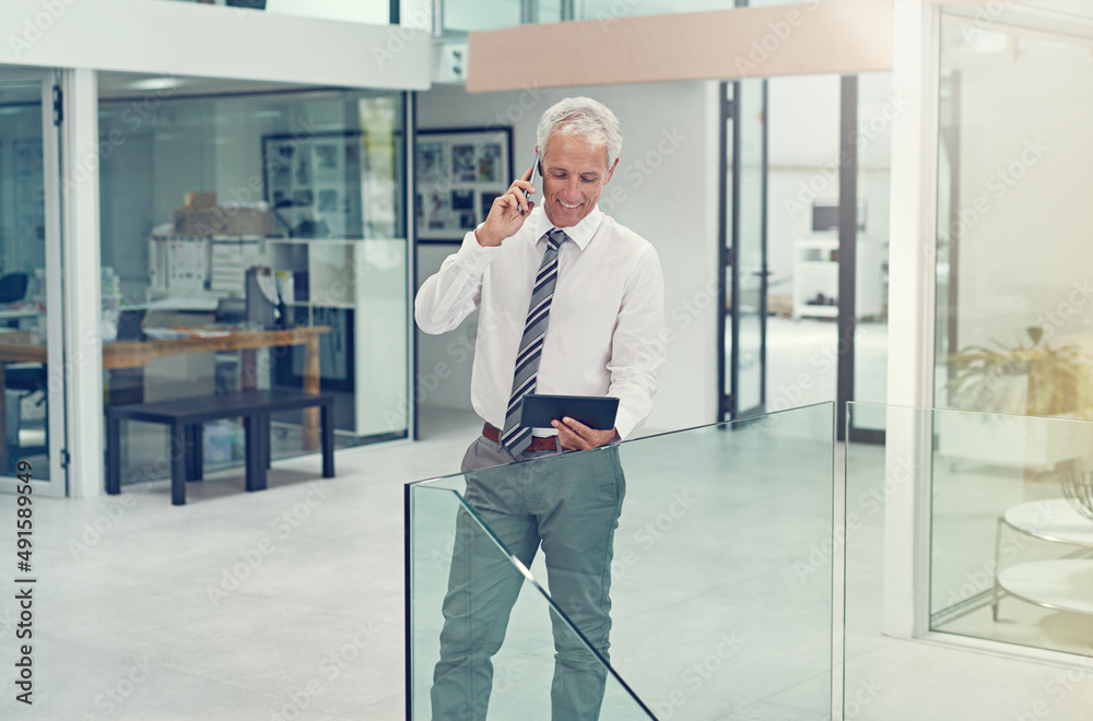 Ill open the email right now. Cropped shot of a businessman using his tablet while talking on his ce