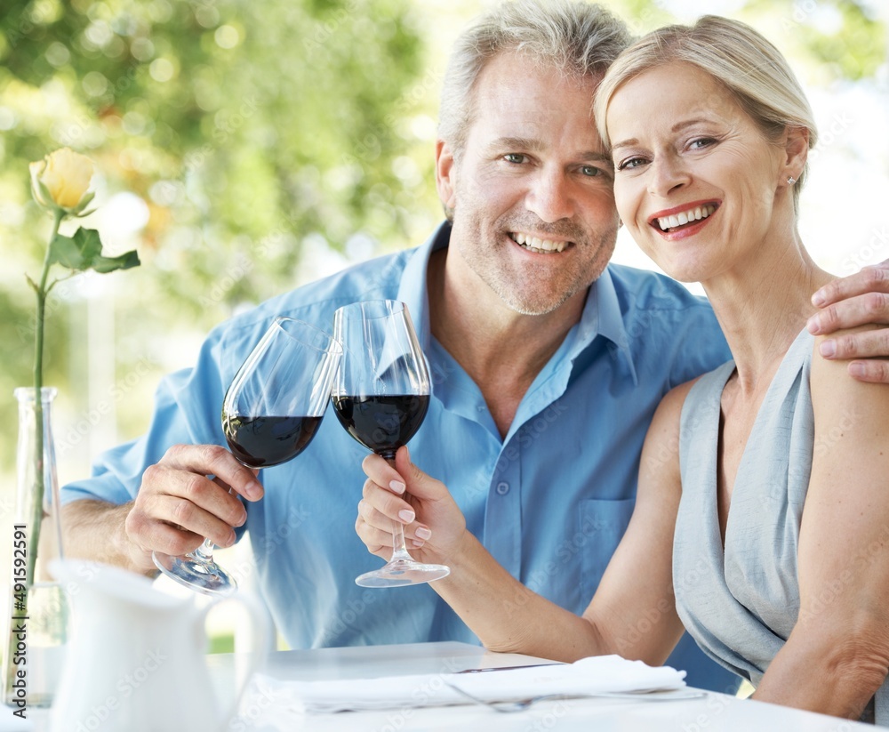 Still in love and committed to each other. Happy mature couple toasting their love with two glasses 