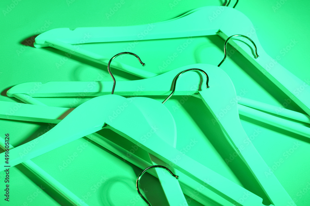 Toned clothes hangers on green background