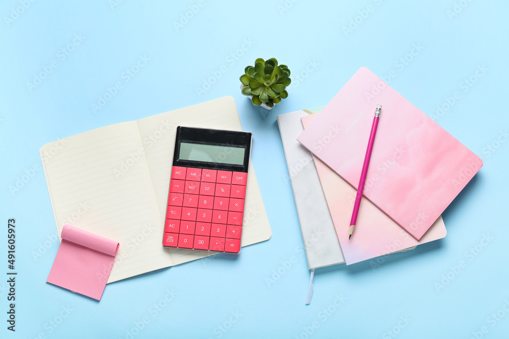 Composition with notebooks, calculator and pencil on color background