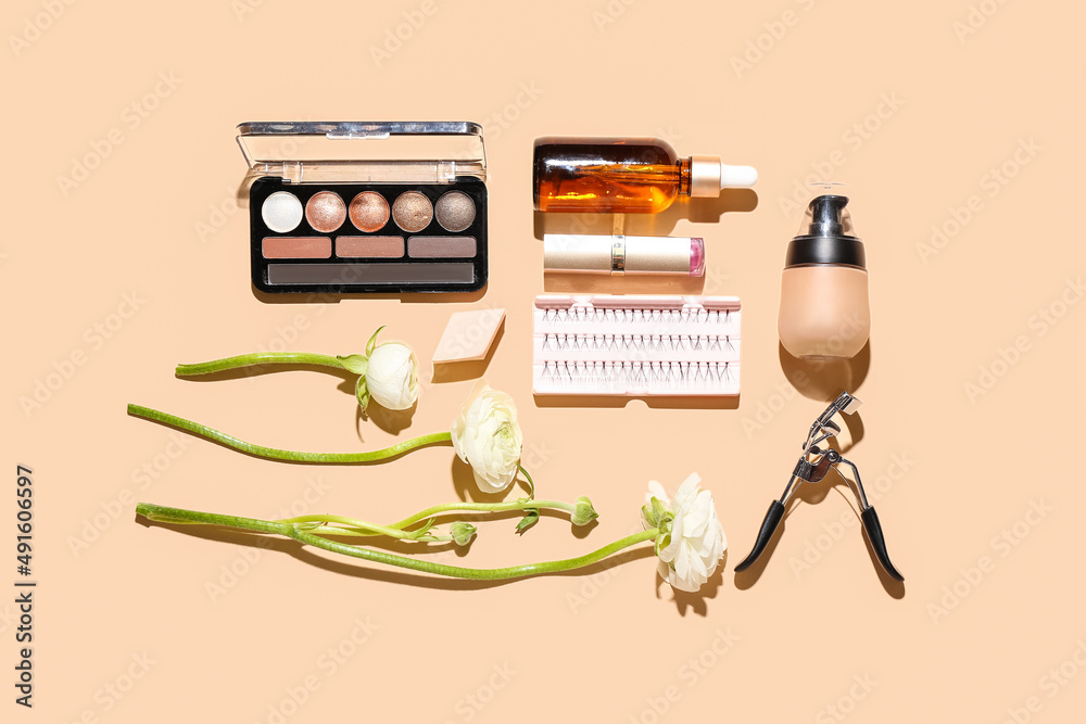 Composition with cosmetics, makeup supplies and ranunculus flowers on color background