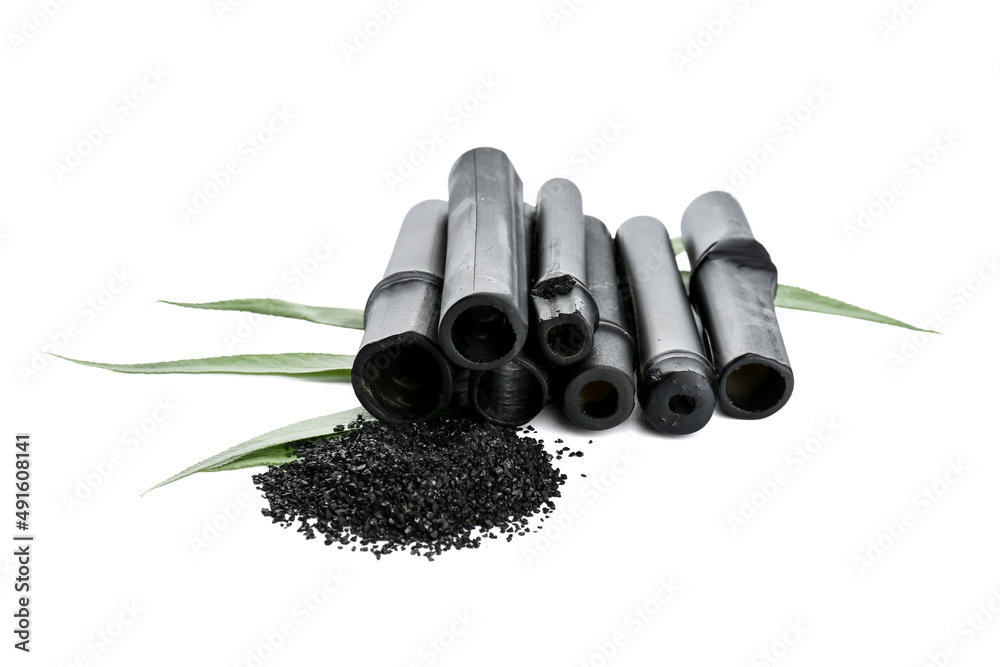 Bamboo sticks and activated carbon powder on white background