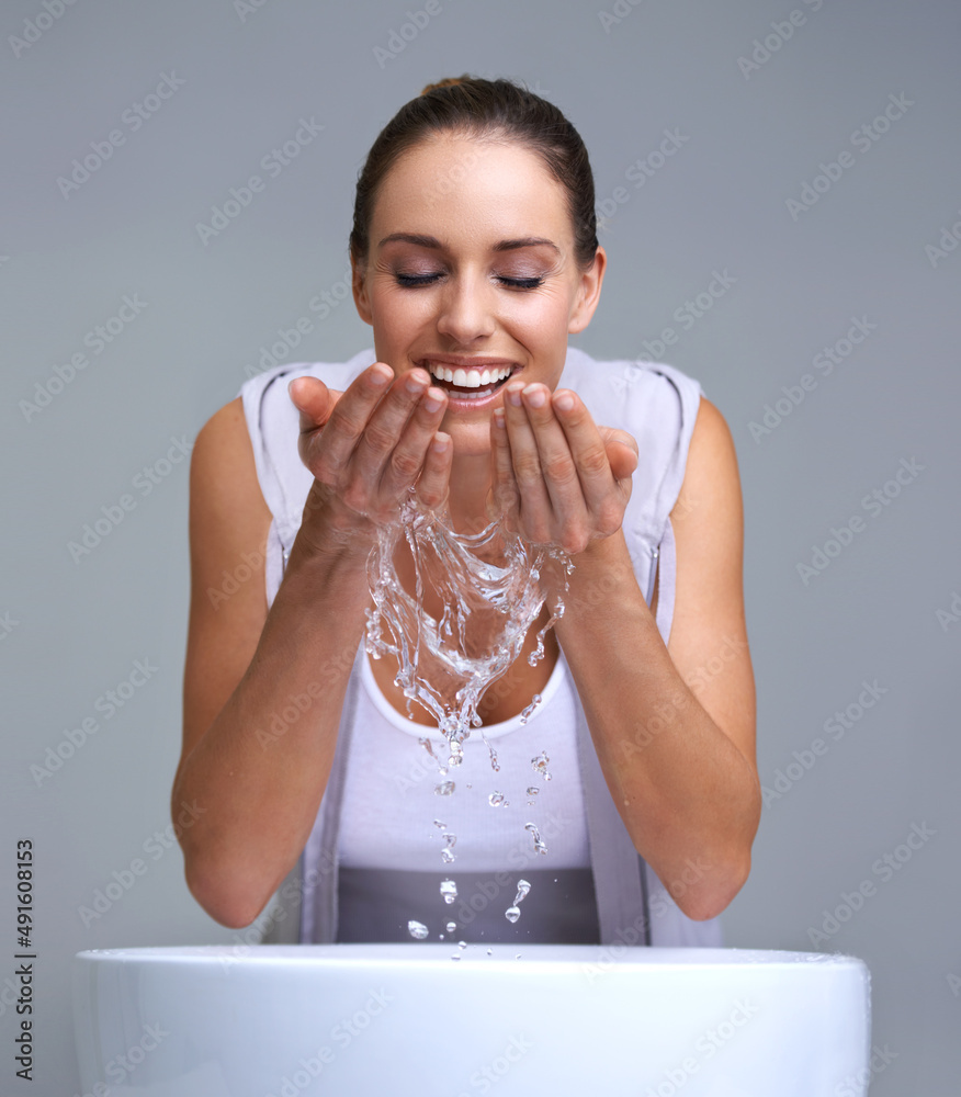 Aah, so refreshing. An attractive young woman washing her face.