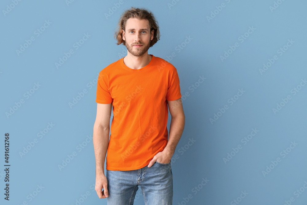 Handsome young man in stylish t-shirt on blue background