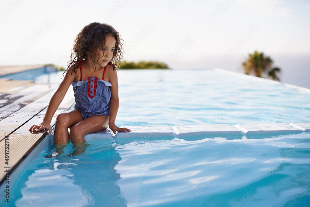 Splish Splash. Shot of a little girl dipping her feet in the pool.