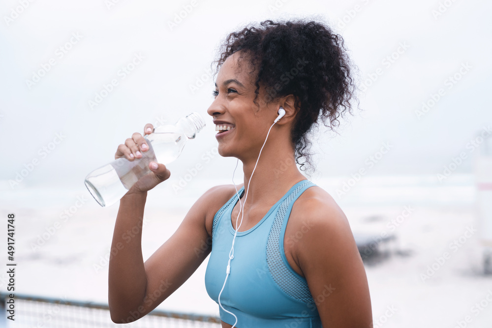 水可以调节你的体温，润滑你的关节。一张运动型年轻女性饮料的照片