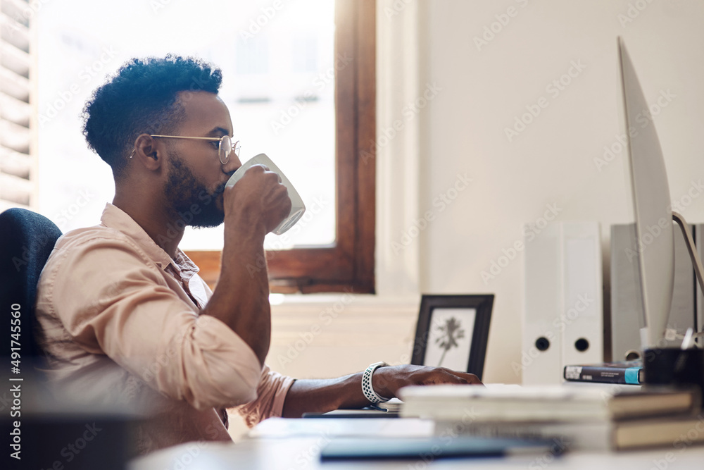 Business is a game where those with tenacity always win. Shot of a young businessman drinking coffee