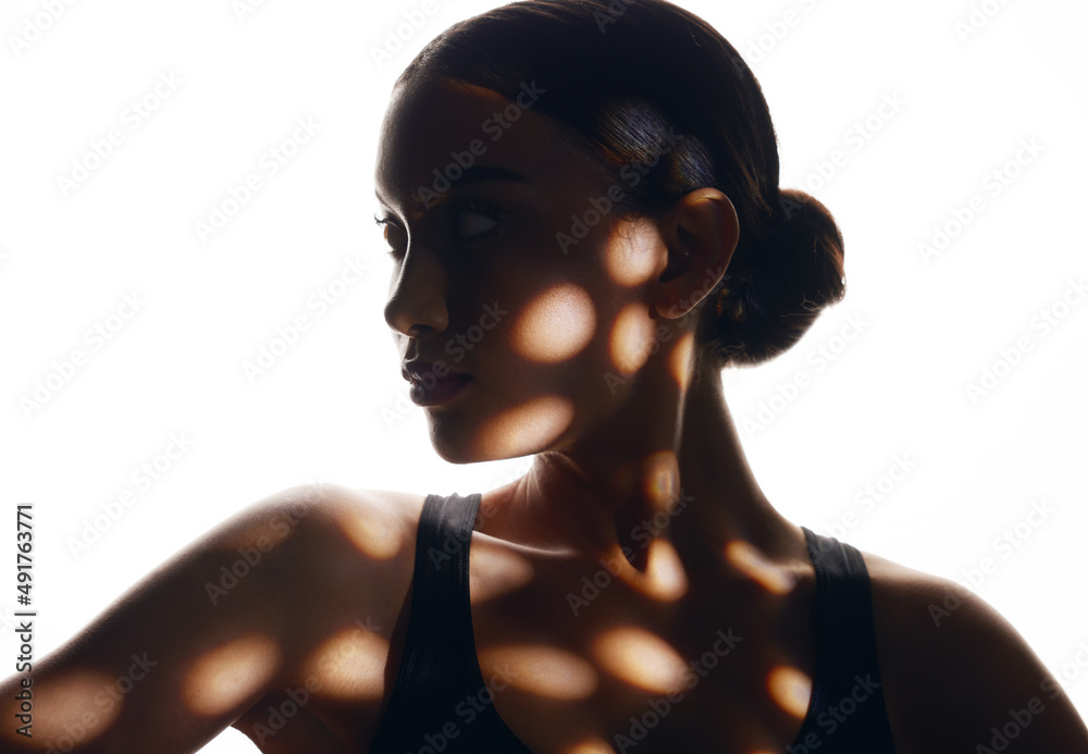 All eyes are on you. Shot of a disco light reflecting on a beautiful young woman.