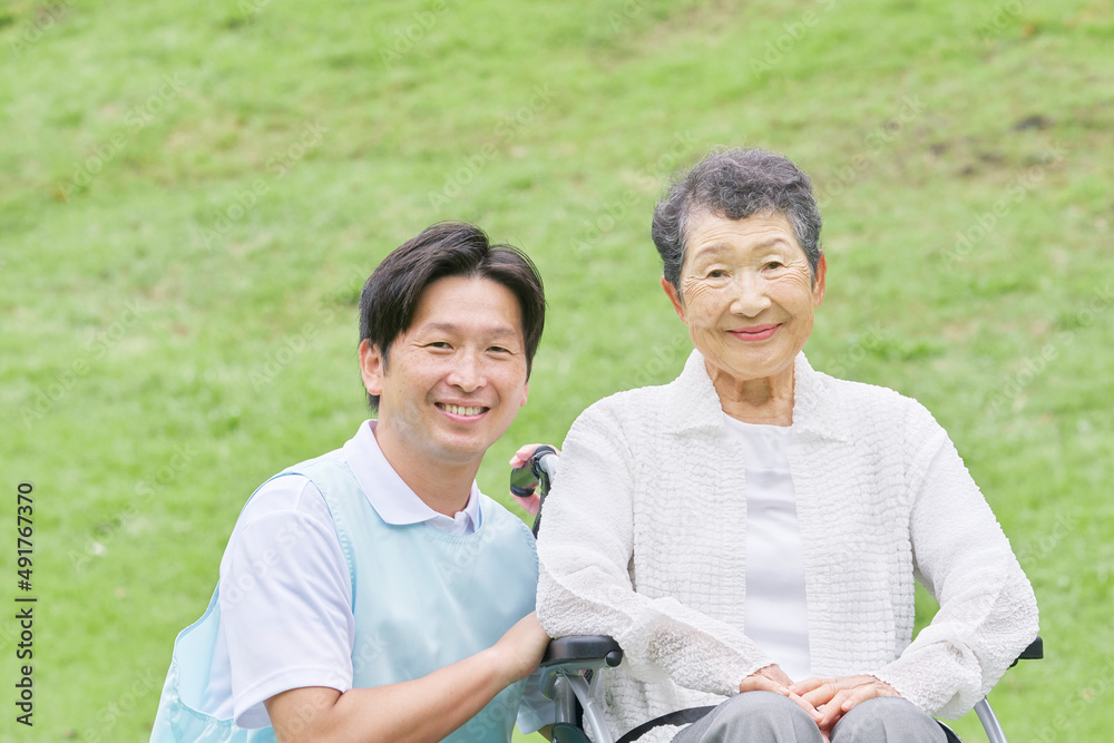 車椅子に乗った高齢者と介護士　屋外ポートレート