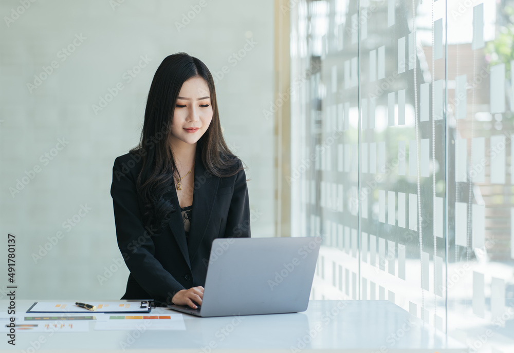 Close up portrait of a beautiful young Asia woman smiling and looking at laptop screen