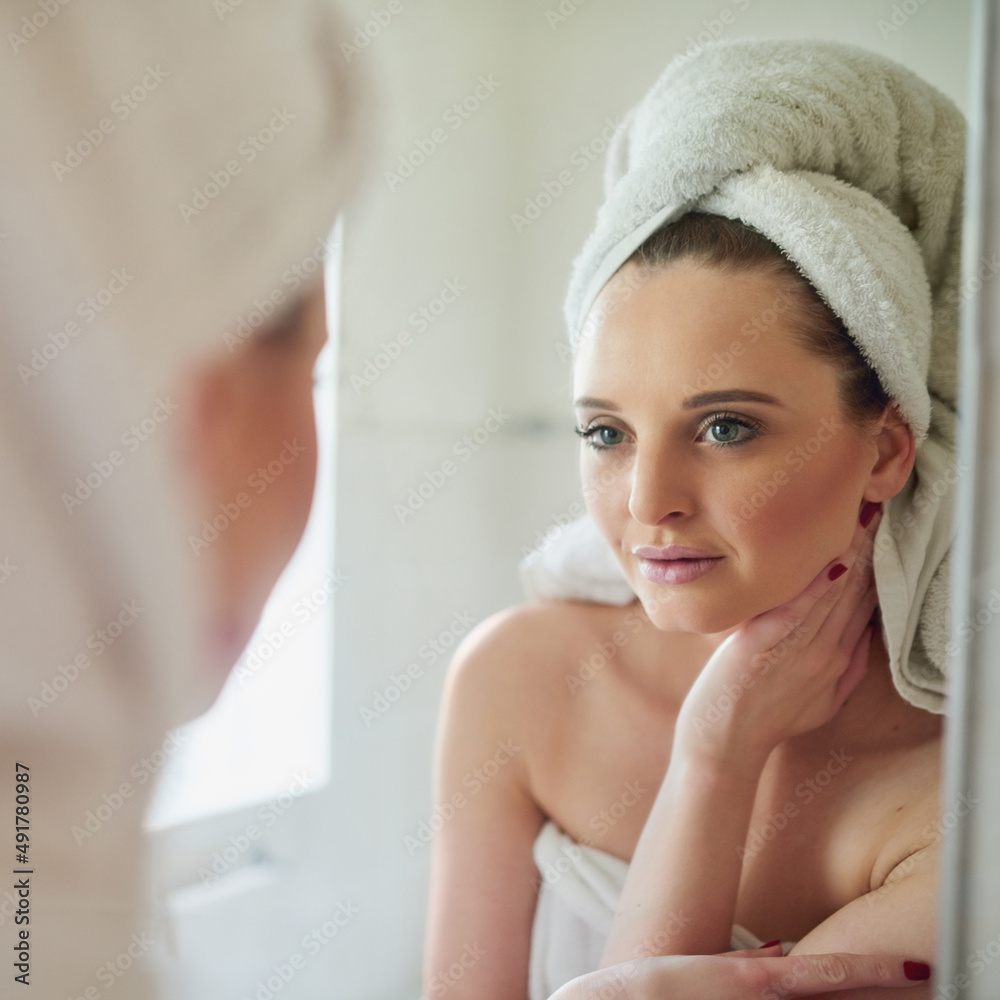 Her new beauty regime is really making her skin glow. Shot of an attractive young woman looking at h