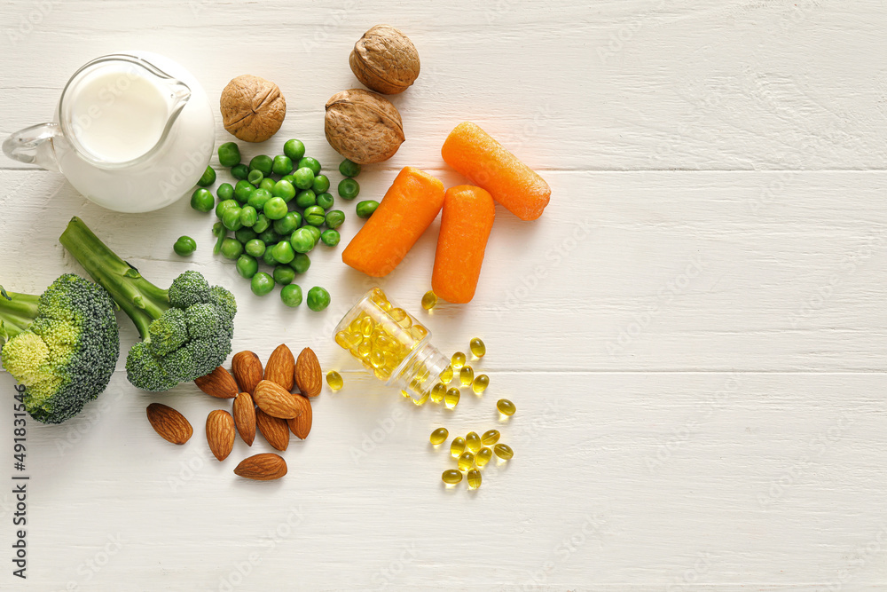 Set of healthy products with pills on white wooden background