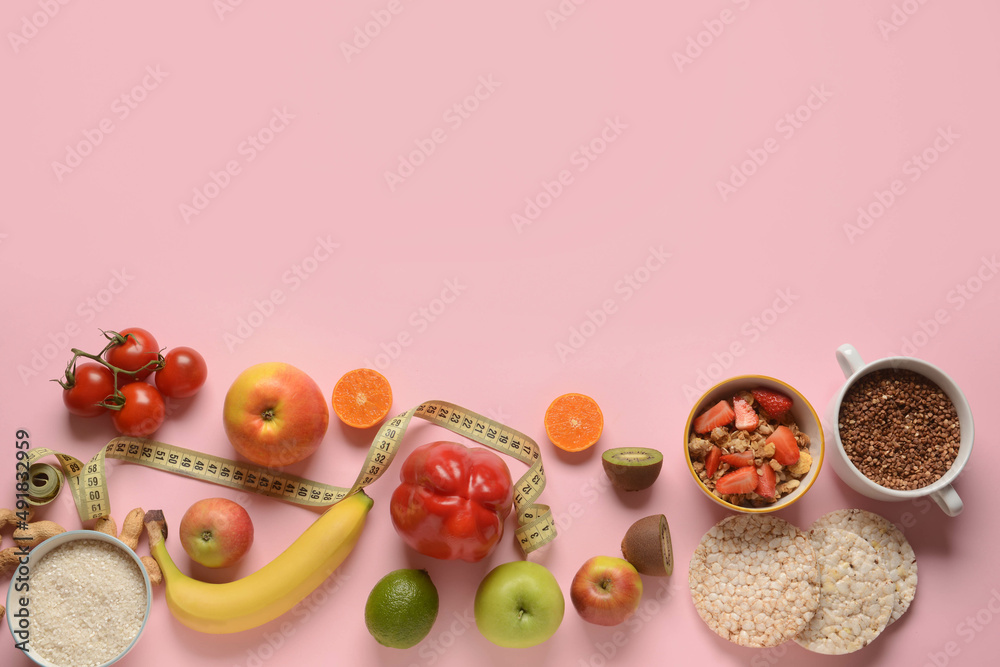 Composition with healthy products and measuring tape on pink background