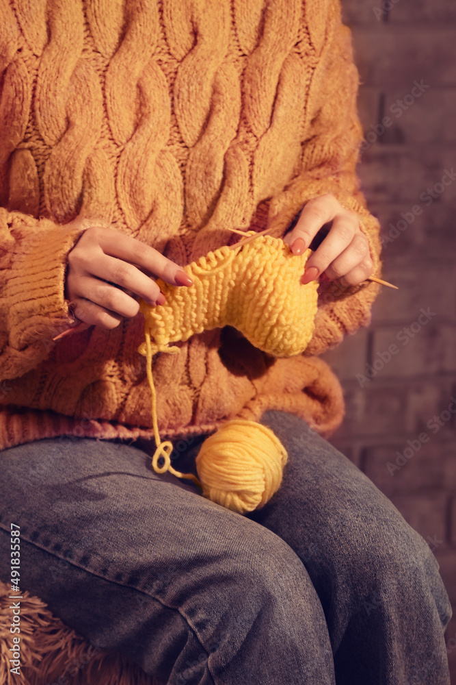 Young woman knitting warm clothes, closeup