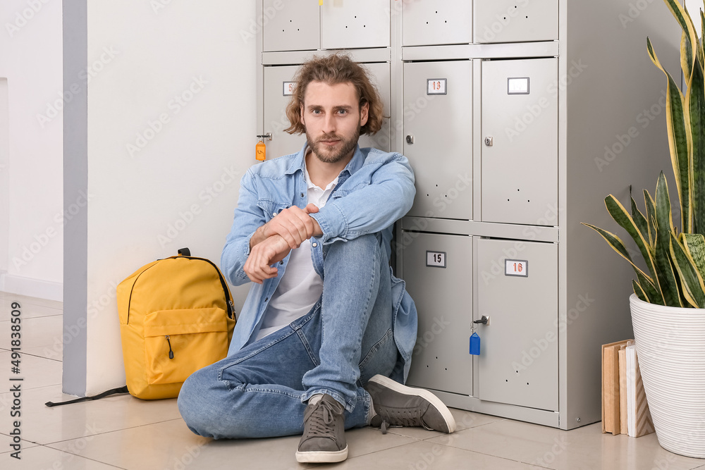 坐在大学储物柜附近的英俊男学生