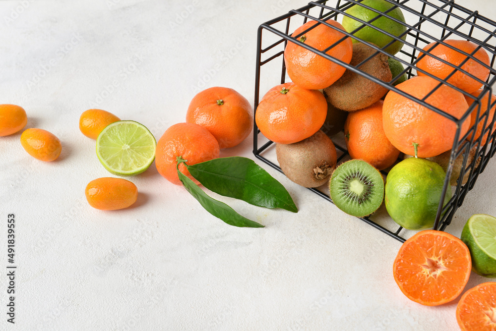 Basket with juicy fruits on light background, closeup