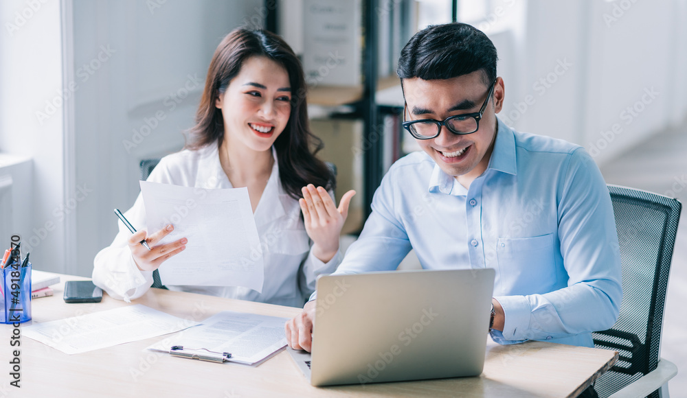 Two Asian businesspeople working at office