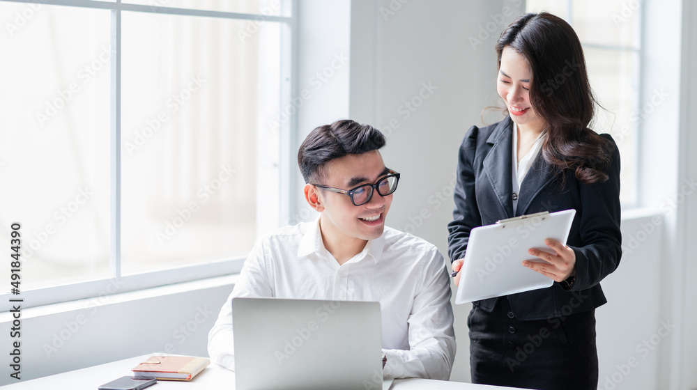 Two Asian businesspeople working at office