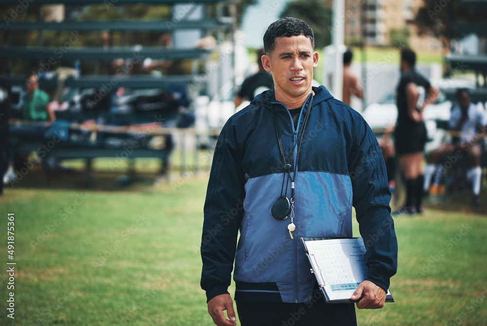 What he does is lead a team of winners. Cropped shot of handsome young rugby coach standing on the f