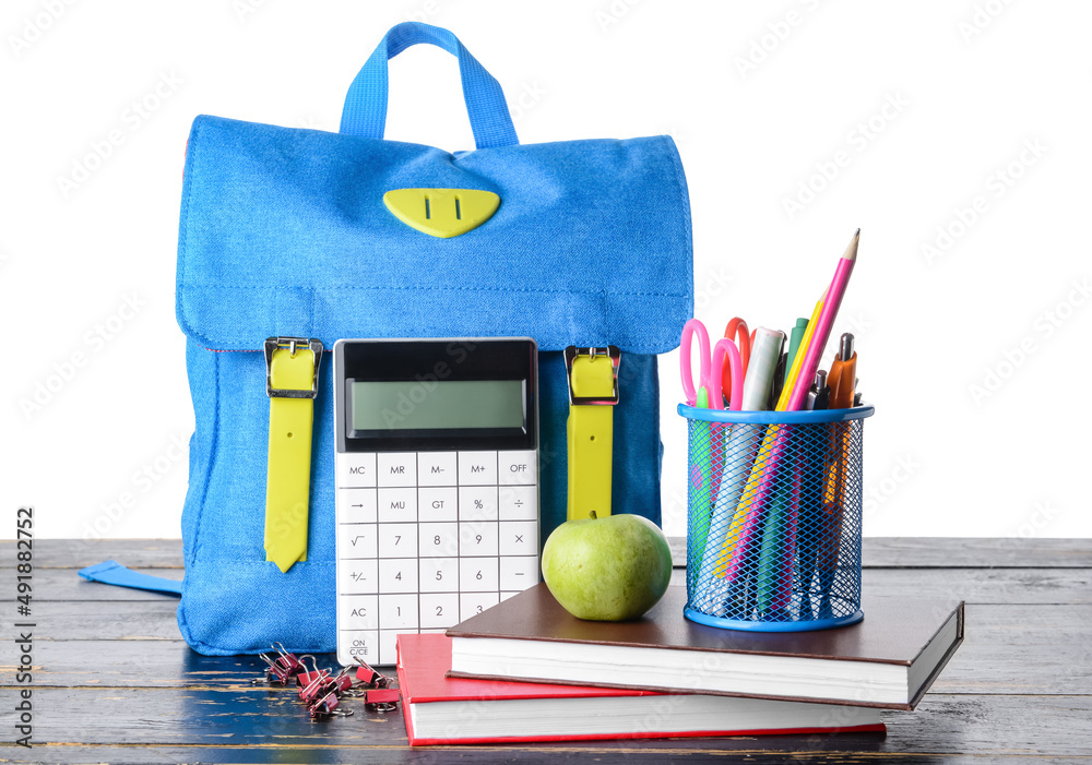 Stylish backpack, stationery and apple on table against white background