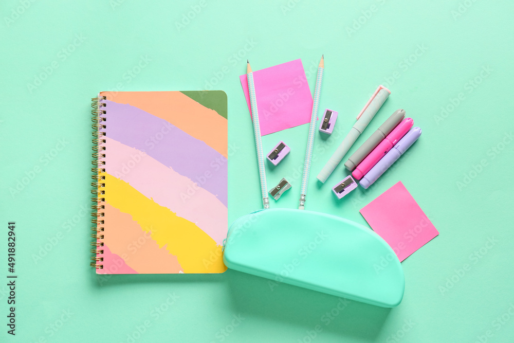 Composition with stylish pencil case and different stationery on color background