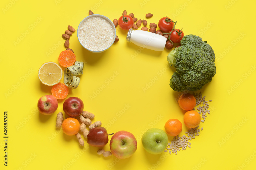 Frame made of different healthy products and measuring tape on yellow background